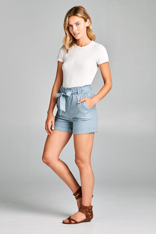 A woman wearing a pair of Linen High Rise shorts 
