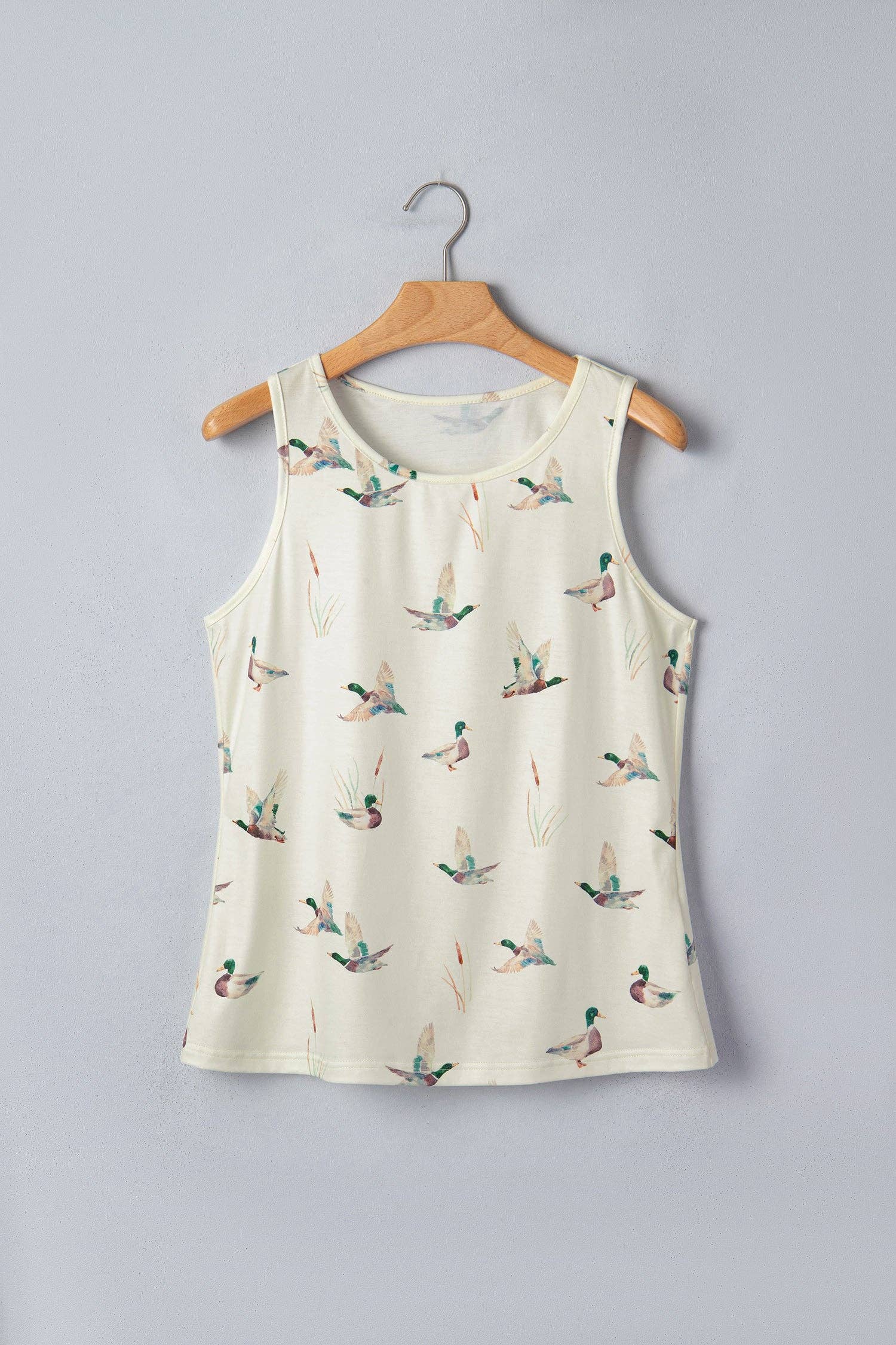 Sleeveless top with duck pattern on a hanger against a gray background