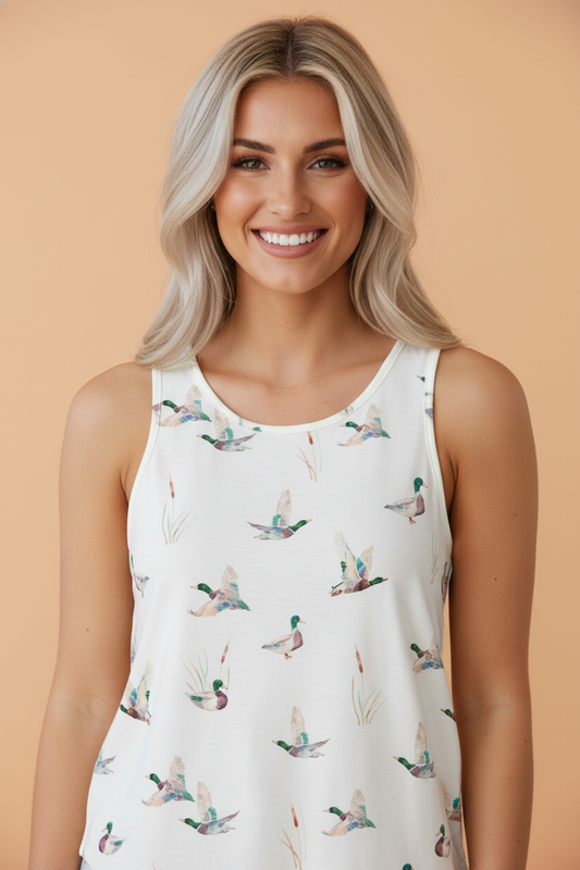 Woman wearing a sleeveless top with duck print against a beige background