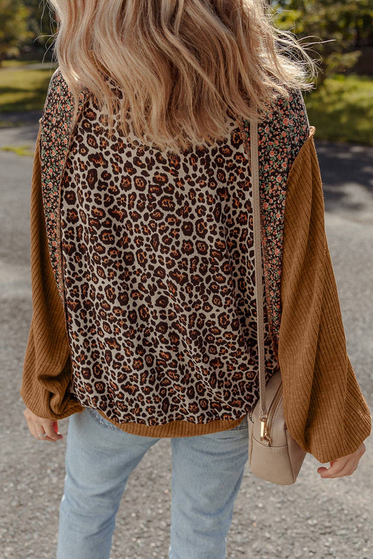 Person wearing a leopard print sweater with brown sleeves outdoors